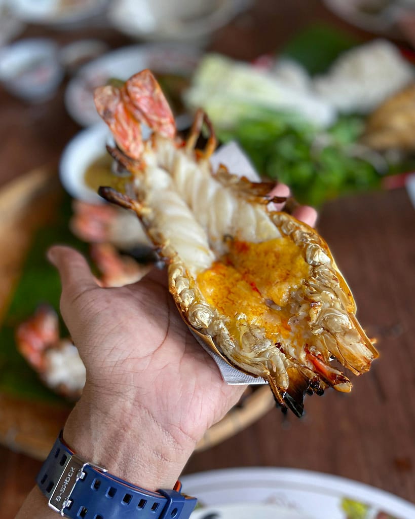 Delicious grilled lobster held in hand, showcasing savory flavors and textures.