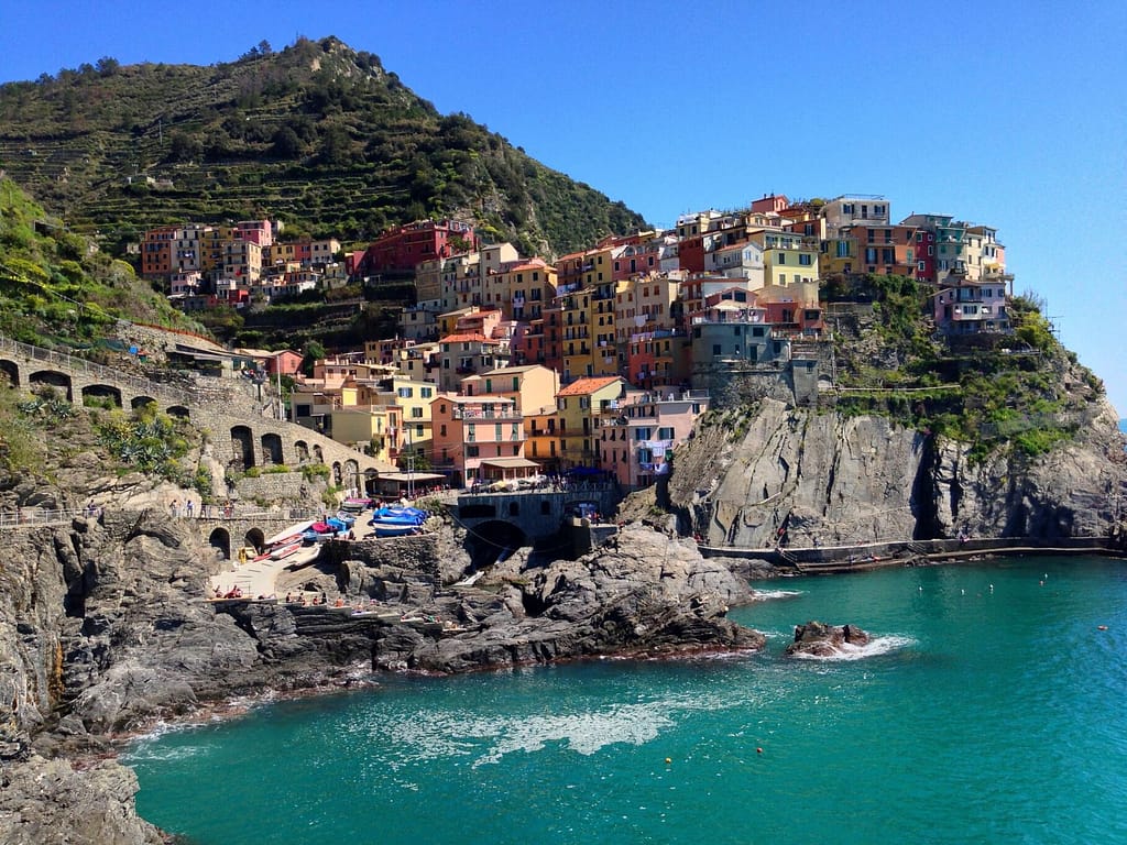Vibrant coastal village of Manarola in Liguria, Italy showcasing colorful buildings on rugged cliffs.