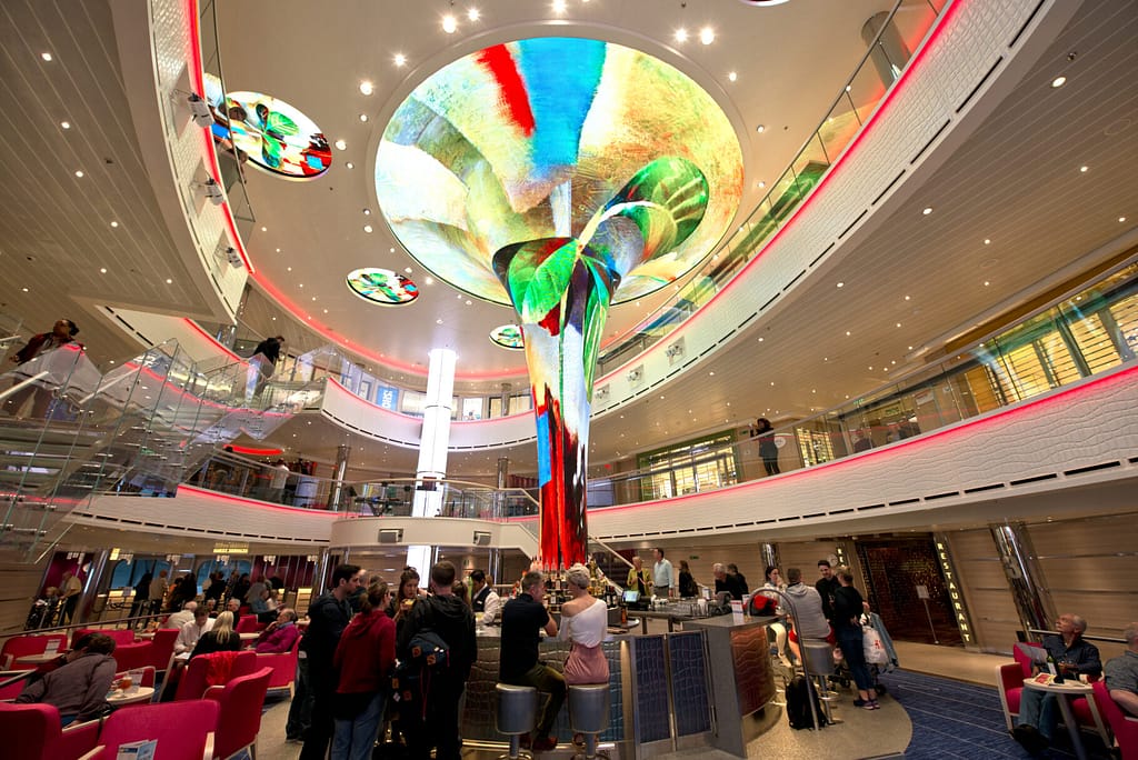 Guests aboard Carnival Horizon occupy the cruise liner's main atrium highlighted by the Dreamscapes LED sculpture. Photo by Andy Newman/Carnival Cruise Line