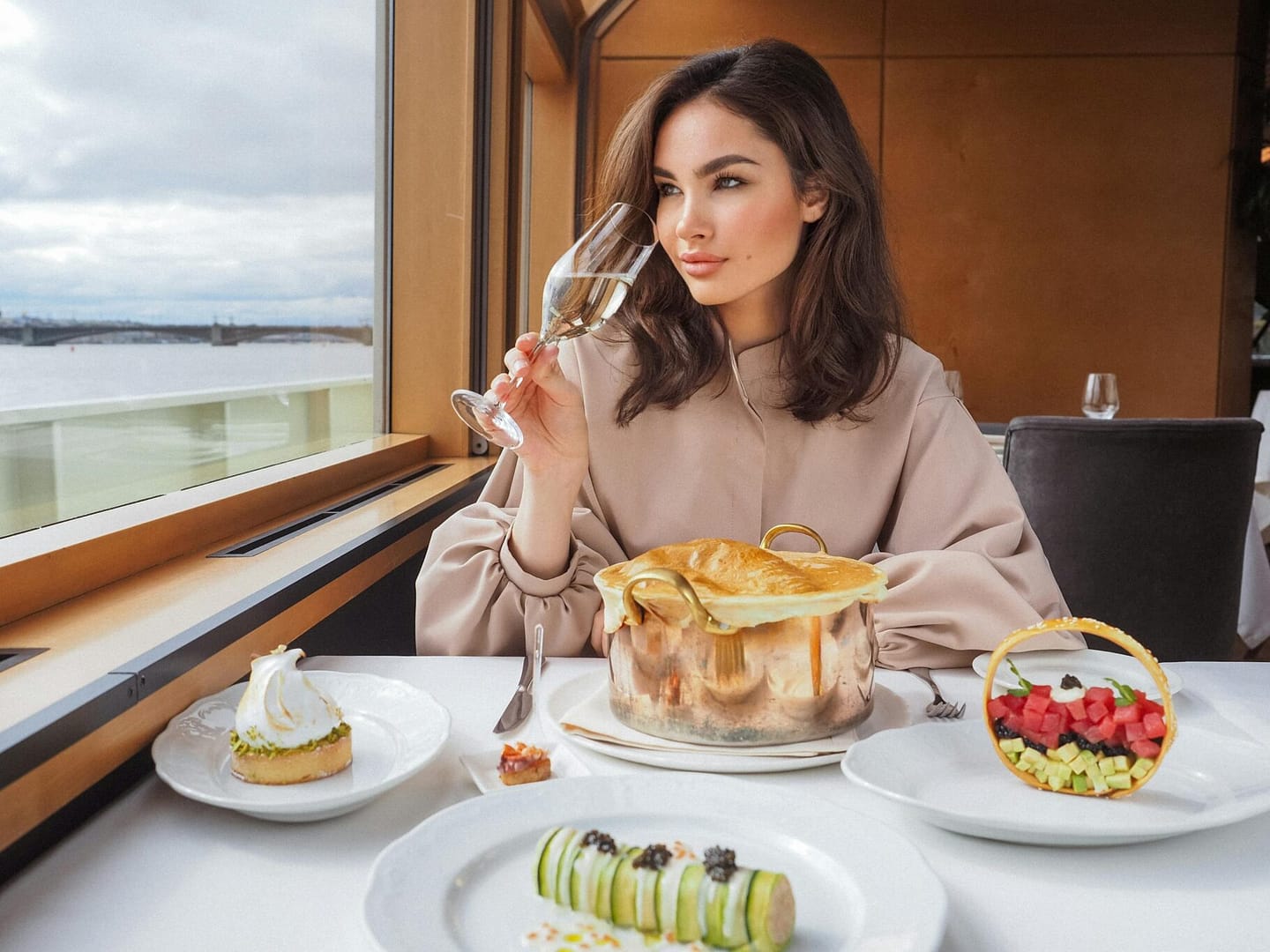 Elegant woman savoring wine during a gourmet meal on a luxury cruise, with sea views.