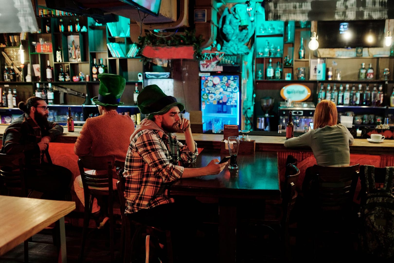 Group of friends enjoying St. Patrick's Day at a cozy pub with vibrant decor.