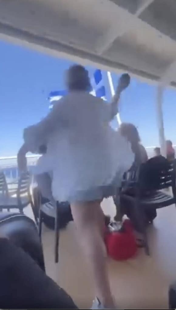 A lady throws a Bluetooth speaker overboard on a Greek cruise