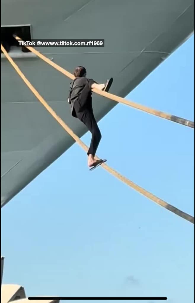 man tries to climb mooring lines onto the Carnival Adventure cruise ship in the Sydney harbor