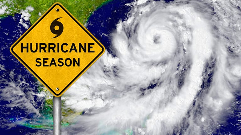 A road sign warning of hurricane season against a background of a hurricane as seen from space