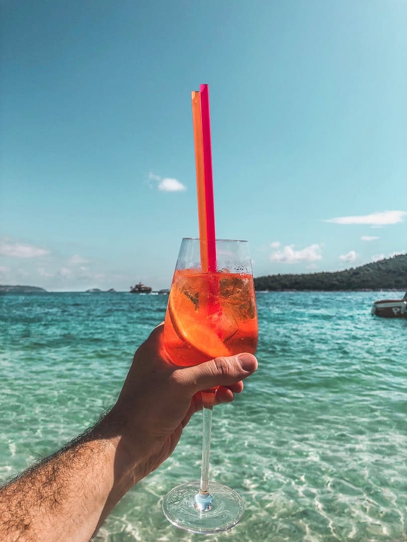 orange liquid in champagne flute with straws