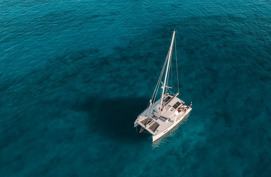 white and blue boat on blue sea