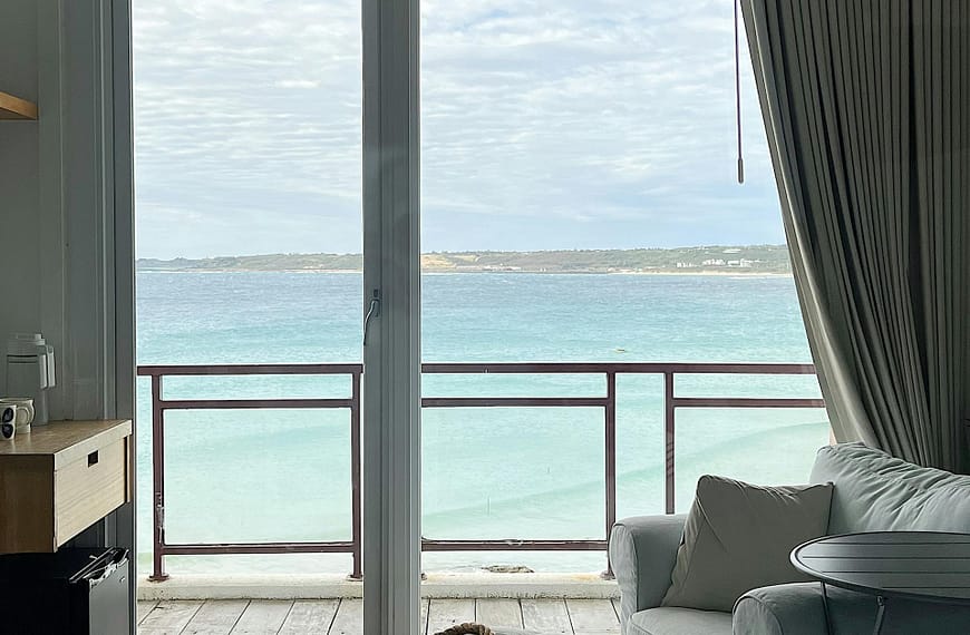 Modern bedroom with a view of the ocean through a large window, perfect for relaxation.