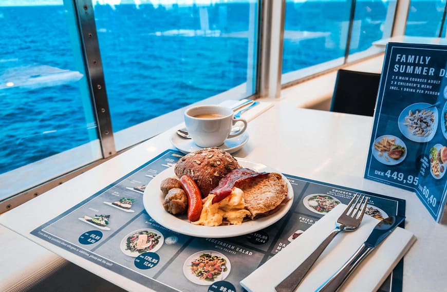 Breakfast setup on a cruise ship with a stunning ocean view through the window.